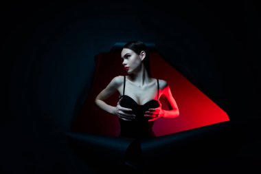 Yırtık delikli dokunmatik göğüslü kadının fotoğrafı. Cazibeli iç çamaşırı giy. Boş uzay koyu renk arka plan..