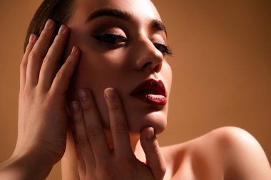 Bej renkli arka planda, makyajlı, güzel bir genç kızın portresi..