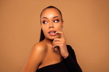 Tatlı rüya gibi çekici tapılası kız dolgun dudaklarına dokun dumanlı gözleri bej rengi arka planda izole olsun.