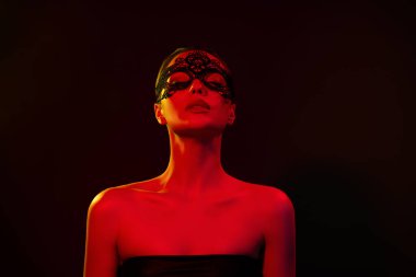 Tutkulu, parlak, çıplak modellerin fotoğrafı. Metres rolünün keyfini çıkar. Siyah, neon ışıklı arka plan..