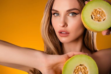 Çekici, güzel bir bayanın parlak sarı arka planda taze meyve gösterirken çekilmiş fotoğrafı..