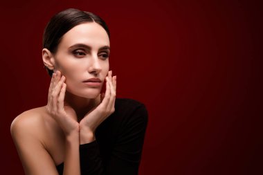 Kızın fotoğrafı boş görünüyor. Dokunma yüzü hassas ten izole edilmiş kırmızı arkaplan..