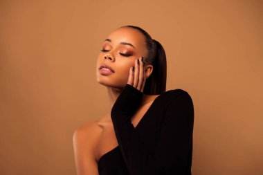 Çekici, çekici bir kadının, profesyonel, güzel bir akşamdan zevk aldığı fotoğraf bej renkli arka planda izole edilmiş bir makyaj..