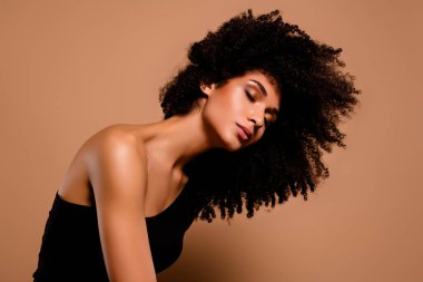 Hayalperest bir kadının, siyah seksi vücut havası ile izole edilmiş bej arka planda çekim yaparken çekilmiş fotoğrafı..