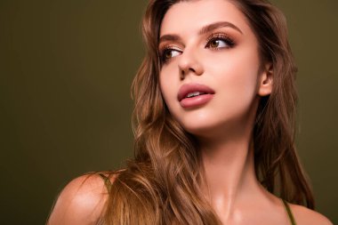 Hoş, zarif, zarif bir hanımın fotoğrafı. Uzun siyah kirpikleri, haki rengi arka planda izole edilmiş..