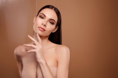 Esmer saçlı, lüks makyaj kapısı olan bir fotoğraf. Boş uzay pastel arka planının yanında duruyor..