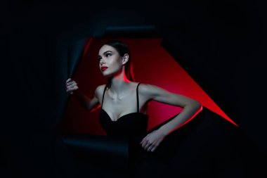 Yırtık siyah delikte bir kadının fotoğrafı. Kırıp geç. Boş alan izole edilmiş renk arkaplanı bak..