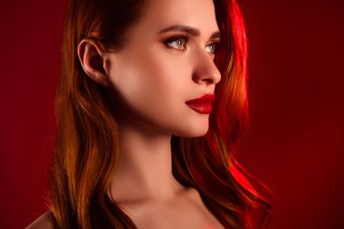 Güzel, çekici bir bayanın fotoğrafı boş görünüyor. Kendine güvenen model omuzlar. Kırmızı arka planda izole edilmiş..