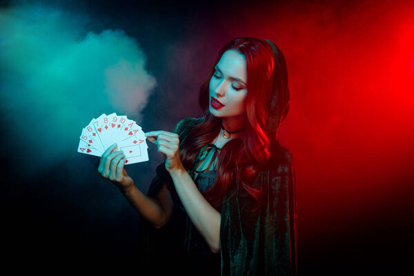 Photo of lady wear dark halloween theme costume playing poker game choose card isolated filter neon mist background.