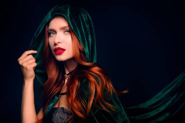 Muhteşem bayan dokunuşu başlık yeşil pelerin çekici görünüyor izole edilmiş koyu mavi arka plan..