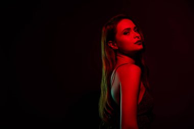 Göz kamaştırıcı bir model. Boş alan pozu. Koyu kırmızı neon arka planda izole edilmiş..