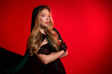 Cadılar Bayramı temalı festivale hazırlanan muhteşem bayan kırmızı arka planda cadı kostümü giyiyor..