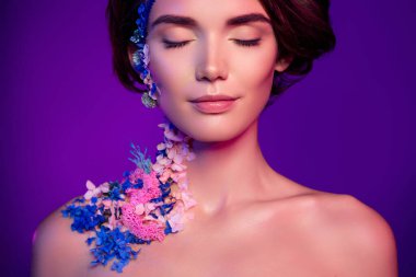 Kapalı gözlü çekici bir kızın fotoğrafı parlak arkaplanda çiçek desenli bir vücut sanatı var..