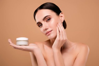 Pastel arka planda izole edilmiş yumuşakça anti-yaş efekti uygulayan sevimli kadının fotoğrafı.