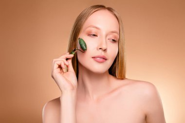 Çekici, çekici, çıplak omuzlu bir kadının fotoğrafı. İzole edilmiş bej arkaplan masajının keyfini çıkar..