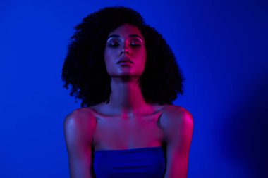 Kapalı gözlü bir kadının fotoğrafı. Kendini izole edilmiş, parlak neon rengi arka plan..