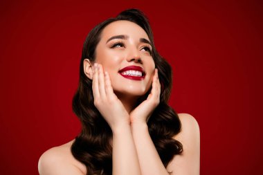 Çekici ve çekici bir kadın modelin kırmızı arka planda mükemmel makyaj yaptığı bir fotoğraf..