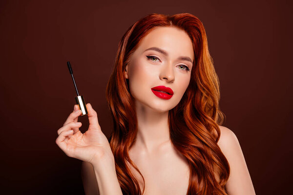 Photo of charming attractive lady model applying mascara volume long lashes isolated on brown color background.