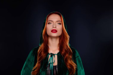 Zalim cadı kadının fotoğrafı. Kapüşonlu yeşil paltolu, izole siyah arka plan..