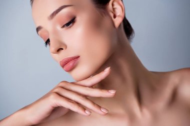 Gri arka planda izole edilmiş kaldırma efektinden keyif alan nazik bayanın yakın fotoğrafını çek.