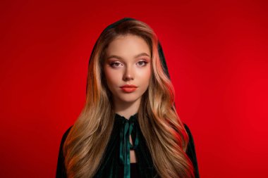 Cadılar bayramı partisi için koyu renk büyücü kostümlü göz kamaştırıcı kızın fotoğrafı. Kırmızı arka plana bak..