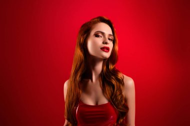 Çekici, çekici, baştan çıkarıcı modelin fotoğrafı. Kırmızı arka planda izole edilmiş seksi deri elbiseler..