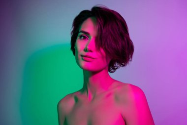 Güzel bir kızın fotoğrafı. Kameraya bak. Değişken neon renkli arka plan..