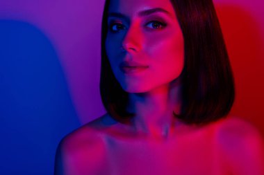 Parlak makyajlı, esmer ve güzel bir kızın fotoğrafı izole edilmiş çok renkli neon arka plan..