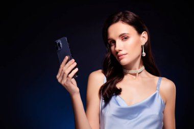 Klas kızın fotoğrafı hücre akıllı aygıtı kullan mavi elbise giy izole edilmiş koyu renk arkaplan.