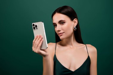 Çok güzel giyinmiş seksi bir bayanın sohbet eden elma tatlısı iPhone modern cihaz izole edilmiş yeşil arka plan.