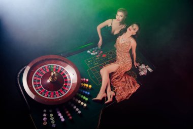 Kumarhanedeki poker masasında yatan güzel bayanların en iyi fotoğrafı 21 bahislerini kazanmalarını kutluyor..