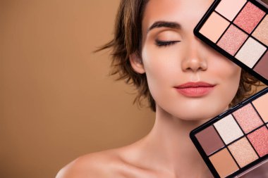 Çekici, narin bir kadının çıplak omuzlarının kesilmiş fotoğrafı paletleri gösteriyor, emtpy alanı izole edilmiş bej arkaplan rengi.