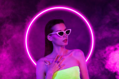 Kız modelinin birleşik fotoğraf kolajı neon menekşe dairesi sis, güneş gözlüğü yüzüklerini boyalı arka planda izole eder..