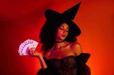 Büyüleyici pokerci kadın cadı karakter Cadılar Bayramı festivalinde sihirbaz kartlarla sihirbazlık yapıyor..