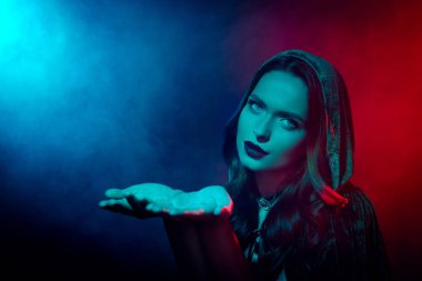 Cadı kostümlü baştan çıkarıcı kadının fotoğrafı el ele tutuşup izole edilmiş neon sisli arka plan reklamları için telif alanını gösterin..