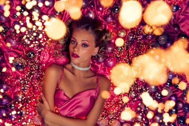 Lüks bir kadının arka planda poz verirken çekilmiş fotoğrafı. Xmas parıltılarıyla süslenmiş..