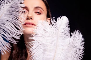 Photo of girl look feel passionate surround with white feather isolated dark color background.