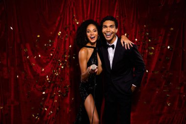 Mutlu insanların, kırmızı arka planda duran yıllık film festivalinin ünlü ödülünün fotoğrafı.