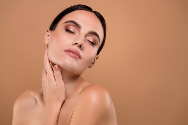 Güzel, rüya gibi, çekici bir kadının çıplak omuzlarının fotoğrafı pastel arka planda izole edilmiş kusursuz bir cilde dokunuyor..