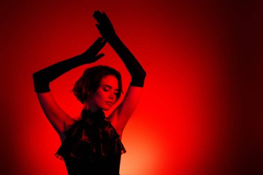 Kırmızı neon arka planda ortaçağ balosu etkinliğini retro kıyafetli şık bayanın fotoğrafı kutladı.