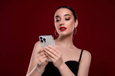 Şık bir bayanın cep telefonuyla izole edilmiş kestane rengi arkaplanı tarama fotoğrafı.