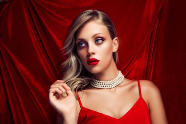 Stüdyoda kırmızı kadife arka planda izole edilmiş nazik kız arkadaş modeli fotoğrafı.