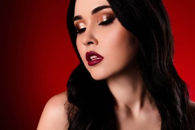 Cazibeli, muhteşem, cilveli, kapalı gözlü kız parlak ruj izole edilmiş kırmızı arkaplanda..