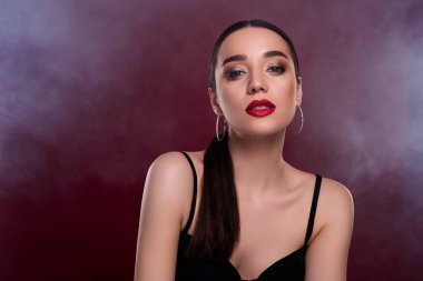 Çekici, muhteşem bir kadının seksi, zengin bir mankenin fotoğrafı. Kestane rengi arka planda izole siyah elbiseler giymiş..