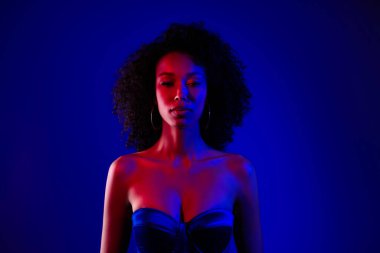 Gece kulübü partisinde kendine güvenen güzel modelin fotoğrafı mavi neon arka planda izole edilmiş..