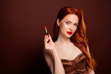 Çekici bayan modelin kahverengi arka planda izole edilmiş kırmızı matte reklamı..