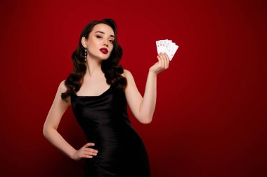 Poker kulübünde çalışan muhteşem başarılı bayanın fotoğrafı. Kırmızı arka planda izole edilmiş proffesional oyuncu..