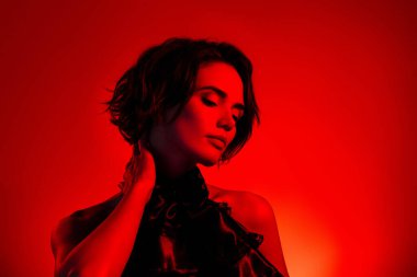 Kırmızı neon disko gece kulübünde gece eğlenen zarif, çekici bir kadının fotoğrafı..