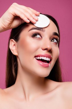 Pamuk pedi takan neşeli bir kızın fotoğrafı boş, izole edilmiş pembe bir arkaplan ara..