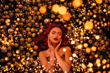 Fotoğrafçı için poz veren zengin kız sihirli oyuncaklara ve altın renkli çelenklere bakıyor..